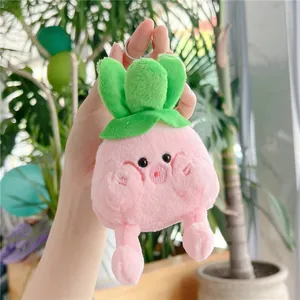 Close-up of a pink plush strawberry keychain with green leaves and metal ring holder