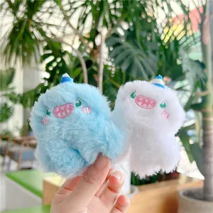 Close-up of cute monster plush hair clips in blue and white with embroidered details