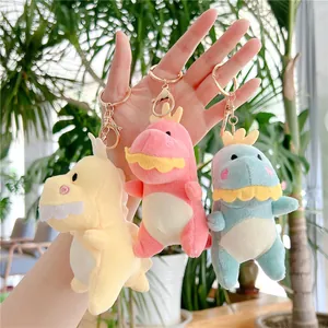 Tre simpatici portachiavi di dinosauro in peluche giallo, rosa e blu con ganci dorati