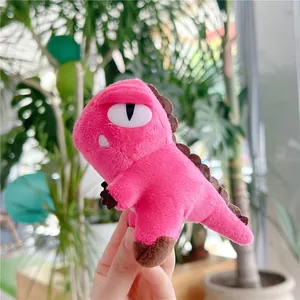 Close-up of a pink plush dinosaur keychain with soft texture and vivid cartoon details