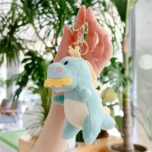 Primo piano di un portachiavi a dinosauro in peluche blu con gancio in metallo dorato