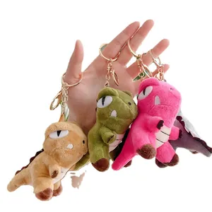 Colorful plush dinosaur keychains in green pink and purple with gold metal hooks