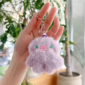 Close-up of purple monster plush keychain with detailed embroidery and soft faux fur texture