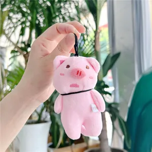 Close-up of pink plush pig keychain with soft texture and black lanyard detail