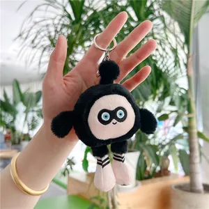 Gros plan d'un porte-clés en peluche noire avec des chaussures roses tenu dans la main
