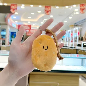 Detail of plush potato keychain featuring embroidered face and woven brown strap