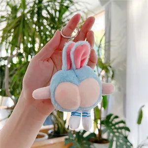 Close-up of funny blue plush rabbit keychain with a peach butt design held in hand