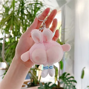 Detailed view of pink plush rabbit keychain with cute peach-shaped butt and striped socks