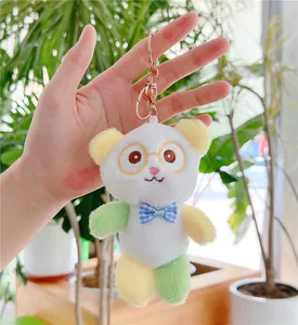 Close-up of cute panda plush keychain with blue bowtie and rose gold metal clasp detail