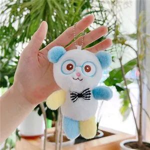 Close-up of cute plush panda keychain with blue ears and black-white checkered bowtie