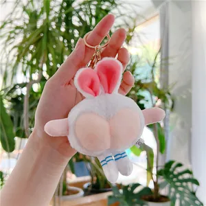 Close-up of white plush bunny keychain with pink peach-shaped bottom and golden clasp