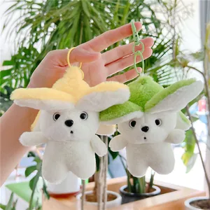 Detail of yellow and green plush banana dog keychains with plastic clips held by hand