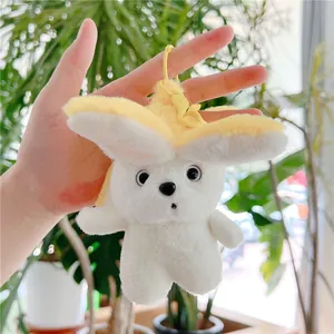 Close-up of cute plush banana dog keychain with soft white fur and yellow petal details