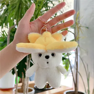 Close-up of cute white plush dog keychain with yellow petal hat and rose gold clasp