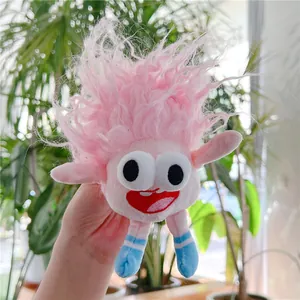 Close-up of pink ugly-cute monster plush toy with big eyes and blue striped legs