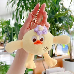 Détail d'un porte-clés oiseau en peluche jaune avec fleur crochetée et fermoir doré