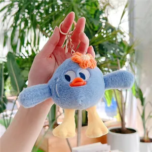 Détail d'un porte-clés oiseau bleu en peluche avec fleur orange et clip métal
