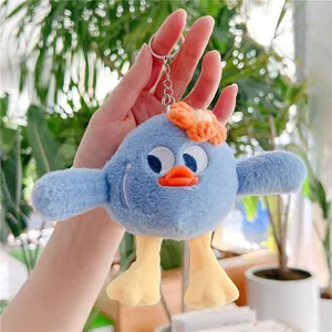Détail d'un porte-clés monstre en peluche bleue avec fleur orange et attache