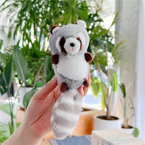 Close-up of soft plush raccoon keychain with striped tail and sturdy metal ring