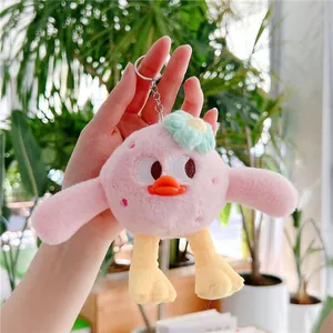 Gros plan du pendentif canard en peluche rose avec yeux brodés et petite fleur verte
