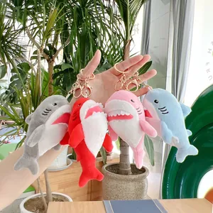 Dettaglio di quattro portachiavi a forma di squalo in peluche con chiusure dorate