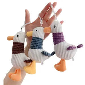 Tres llaveros de pato de peluche en pana marrón, azul y violeta con ganchos blancos