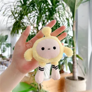 Gros plan d'un charm peluche œuf jaune avec chaussettes rayées tenu près de plantes
