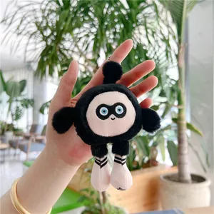 Gros plan d'un porte-clés en peluche noire avec visage rose et détails brodés