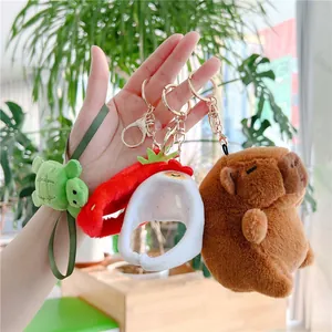 Close-up of capybara plush keychain set with turtle shell and strawberry hat charms