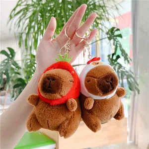 Detailed view of capybara plush keychains with strawberry and chicken hat designs
