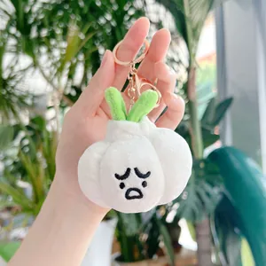 Detail of cute plush garlic keychain with funny sad face and rose gold hardware