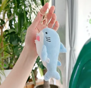 Dettaglio ravvicinato di portachiavi a squalo in peluche blu con chiusura in metallo rosa