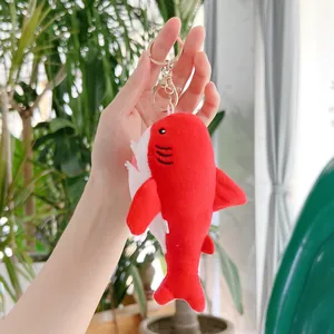 Dettaglio del portachiavi a forma di squalo in peluche rosso con chiusura dorata