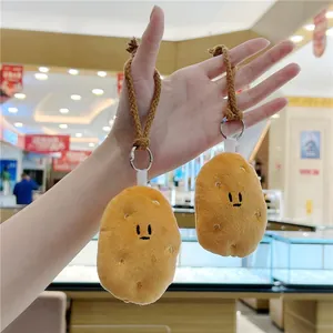 Macro detail of two cute plush potato keychains with black embroidery and metal rings