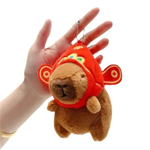 Plush capybara keychain with festive red hat and gold coin icons in hand display