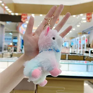 Close-up of fluffy colorful alpaca plush keychain with golden metal clasp and blue beads