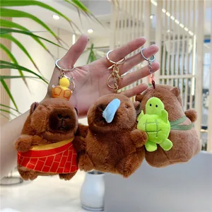 Trois porte-clés capybara en peluche avec couronne, nœud bleu et petite tortue verte