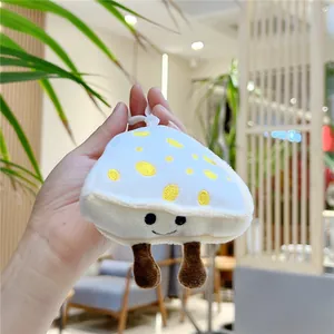 Cute white mushroom plush pendant with yellow dots and smiling face on blurry background