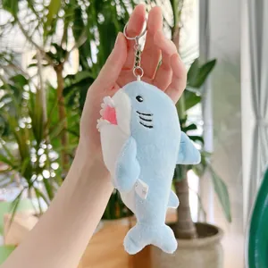 Primo piano di un portachiavi a squalo di peluche blu con tessuto morbido e anello metallico