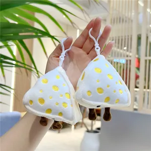 Detail view of two cute cheese plush pendants with soft fur and white hanging clips