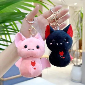 Close-up of pink and black bat plush keychains with detailed heart embroidery