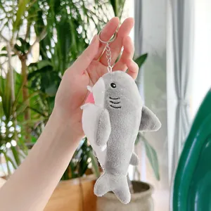 Dettaglio di un piccolo portachiavi a forma di squalo in peluche con anello in metallo