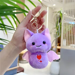 Detailed view of a purple plush bat keychain with pink wings and heart embroidery