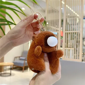 Détail d'un porte-clés en peluche Capybara marron doux avec anneau doré et nez blanc