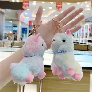 Detail of colorful plush alpaca keychains featuring soft faux fur and metallic gold clasp