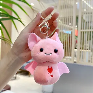 Close-up of pink plush bat keychain with embroidered devil heart and metal ring