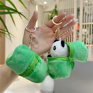 Detail of cute panda plush toy inside green bamboo tube pendant with gold keychain