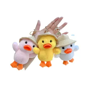 Tre portachiavi a forma di papera di peluche con cappelli di paglia in rosa, giallo e bianco