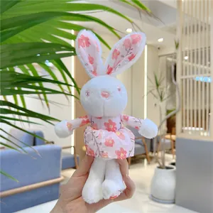 Close-up of white plush bunny keychain with pink floral dress and matching inner ear details