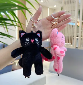 Close-up of pink polka dot and black plush cat keychains with gold metal lobster clasps